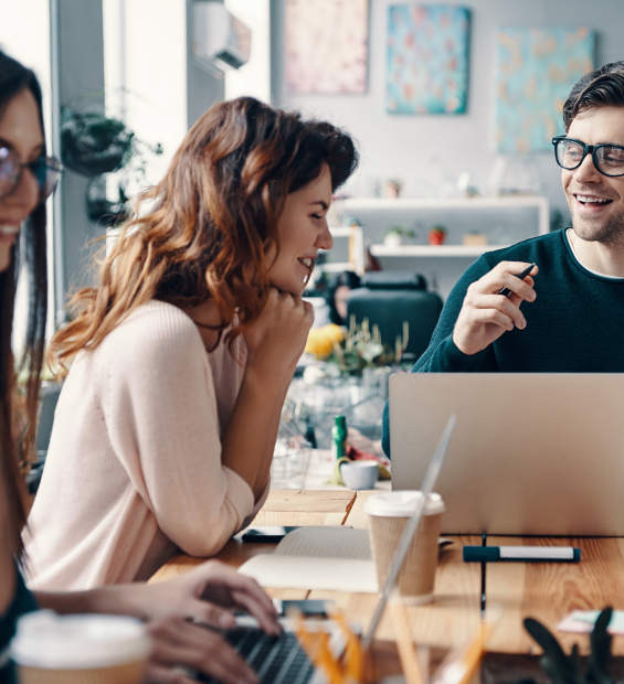 Young business professionals. Group of young modern people in smart casual wear discussing something and smiling while working in the creative office